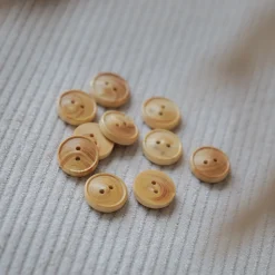 petits boutons en bois posés sur un tissu velours côtelé