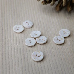boutons écrus mouchetés sur velours écru