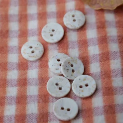 boutons en polyester recyclé sur une flanelle vichy orange